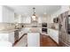 Spacious kitchen featuring white cabinets, granite countertops, stainless steel appliances, and a center island at 3577 S Hillcrest Dr, Denver, CO 80237