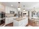 Bright kitchen featuring white cabinetry, stainless steel appliances, a granite island and modern lighting at 3577 S Hillcrest Dr, Denver, CO 80237