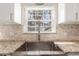 Close-up of kitchen sink with modern faucet, granite countertops, and window view at 3577 S Hillcrest Dr, Denver, CO 80237