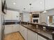 Open basement bar area with granite countertops, white cabinets, and a view of a cozy fireplace at 10531 Lieter Pl, Lone Tree, CO 80124