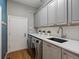 Functional laundry room with modern washer and dryer, neutral cabinets and countertops, and ample storage at 10531 Lieter Pl, Lone Tree, CO 80124