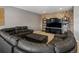 Spacious living room with ample seating, a large flat screen TV, and a brick accent wall with shelves at 10531 Lieter Pl, Lone Tree, CO 80124