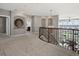Upstairs loft area showcasing curved railings, architectural details, and views from large arched windows at 10531 Lieter Pl, Lone Tree, CO 80124