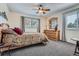 Comfortable bedroom with a ceiling fan, large windows and natural wood furniture at 5604 S Lisbon Way, Centennial, CO 80015