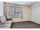 Comfortable bedroom featuring a couch, large window and a closet with bi-fold doors at 5604 S Lisbon Way, Centennial, CO 80015