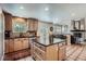 Open-concept kitchen with a central island, adjoining dining area, and a fireplace for a cozy atmosphere at 5604 S Lisbon Way, Centennial, CO 80015