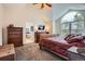 Bright main bedroom with vaulted ceiling, arched windows, television and a decorative wood bed frame at 5604 S Lisbon Way, Centennial, CO 80015