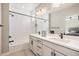 Well-appointed bathroom featuring a double vanity, stylish lighting, and tub with shower at 888 S Valentia St # 106, Denver, CO 80247