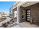 Modern townhome with a dark brick exterior, multi-paneled front door, and landscaped pathway at 888 S Valentia St # 106, Denver, CO 80247