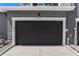 Modern black garage door with white trim, flush finish, and house number 14-106 at 888 S Valentia St # 106, Denver, CO 80247