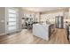 Contemporary kitchen featuring white cabinetry, a waterfall island, and an open layout to the dining area at 888 S Valentia St # 106, Denver, CO 80247