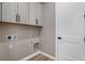 Laundry room with grey cabinets, utility sink, and washer/dryer hookups at 888 S Valentia St # 106, Denver, CO 80247