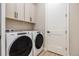 Functional laundry room with upper cabinets and modern washer and dryer units at 888 S Valentia St # 106, Denver, CO 80247