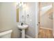 Bright powder room featuring a pedestal sink, modern fixtures, and a neutral color palette at 888 S Valentia St # 106, Denver, CO 80247