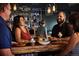 A group of people smiling and enjoying drinks and appetizers at a restaurant at 888 S Valentia St # 106, Denver, CO 80247