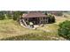 Expansive brick home featuring a covered patio, lush landscaping, and a sprawling lawn at 31200 E 145Th Ave, Brighton, CO 80603