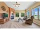 Spacious living room features a fireplace, a ceiling fan, and large windows showcasing outdoor views at 31200 E 145Th Ave, Brighton, CO 80603