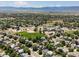 Expansive aerial view of a residential neighborhood, complete with green spaces, a school, and mountain views at 2548 Foothills Canyon Ct, Highlands Ranch, CO 80129