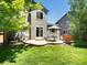 Spacious backyard with a lush lawn, patio, grill, and mature trees perfect for outdoor entertaining at 2548 Foothills Canyon Ct, Highlands Ranch, CO 80129