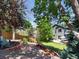 Backyard featuring gravel, brick fire pit, well-maintained lawn, and mature trees at 2548 Foothills Canyon Ct, Highlands Ranch, CO 80129