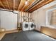 Unfinished basement with laundry machines featuring a gray floor, and exposed ceiling rafters at 2548 Foothills Canyon Ct, Highlands Ranch, CO 80129