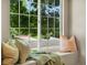 Inviting window seat with plush pillows and a cozy blanket, offering a peaceful view of the outdoors at 2548 Foothills Canyon Ct, Highlands Ranch, CO 80129