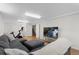 Finished basement with a cozy seating area, large TV, and exercise equipment at 1581 S Kendall St, Lakewood, CO 80232