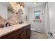 Bright bathroom features double sinks, stone accent wall, and neutral tile floors at 1581 S Kendall St, Lakewood, CO 80232