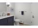 Well-maintained bathroom with navy blue vanity, modern faucet, and tiled flooring at 1581 S Kendall St, Lakewood, CO 80232
