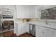 Bright kitchen with white cabinets, stainless steel appliances and a view into the dining room at 1581 S Kendall St, Lakewood, CO 80232