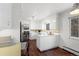 Bright kitchen featuring white cabinetry, modern lighting, and hardwood flooring at 1581 S Kendall St, Lakewood, CO 80232