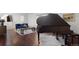 A grand piano sits off the living room area featuring a wooden bench and adjacent staircase at 1581 S Kendall St, Lakewood, CO 80232