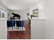 Open-concept living room with hardwood floors, piano, and picture window at 1581 S Kendall St, Lakewood, CO 80232