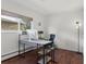 Bright office space with wood floors, large window, modern desk, and stylish lighting fixture at 1581 S Kendall St, Lakewood, CO 80232