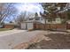 View of side yard, gravel driveway, and wooden fence surrounding property at 1581 S Kendall St, Lakewood, CO 80232