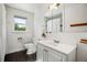 Bathroom featuring a window, toilet, and vanity with undermount sink at 1860 W Iris Cir, Littleton, CO 80120