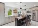 Stylish kitchen with stainless appliances, pendant lighting, island seating, and ample counter space at 1860 W Iris Cir, Littleton, CO 80120