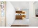 Bright room with white walls and carpet, an open floorplan to a kitchen with wood cabinets at 12560 E Warren Dr # E, Aurora, CO 80014