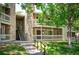 Exterior view of the condo building with stone accents, balconies, and well-maintained landscaping at 8225 Fairmount Dr # 10-203, Denver, CO 80247