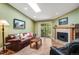 Bright living room featuring hardwood floors, fireplace, and sliding glass doors to a balcony at 8225 Fairmount Dr # 10-203, Denver, CO 80247
