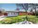 A lush, green backyard featuring a cozy sunroom addition to the brick-and-blue home exterior at 921 S Wheeling St, Aurora, CO 80012