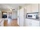 Galley kitchen with white appliances and tiled floors leading to living space at 921 S Wheeling St, Aurora, CO 80012
