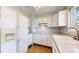 Kitchen featuring white appliances, cabinets, and a double basin sink at 921 S Wheeling St, Aurora, CO 80012