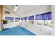 Sunny sunroom with multiple windows, blue carpet, and access to the outside at 921 S Wheeling St, Aurora, CO 80012