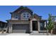Beautiful two-story home featuring a stone and siding exterior, attached two-car garage, and covered porch at 6065 Caribou Dr, Brighton, CO 80601