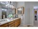 Bathroom featuring double vanity, wooden cabinets and framed mirrors, and modern lighting at 16397 Sheridan Dr, Parker, CO 80134