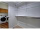 A walk-in closet includes a wall-mounted shelf and is located near laundry machines at 16397 Sheridan Dr, Parker, CO 80134