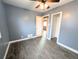 Bedroom features wood-look floors, neutral paint, and a ceiling fan with updated lighting at 2696 S Grove St, Denver, CO 80219