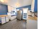 Functional kitchen featuring stainless steel refrigerator, gas range and bright blue walls at 2696 S Grove St, Denver, CO 80219