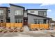 Contemporary townhome featuring gray siding, wood fence, and a red front door at 9445 W 58Th Cir # C, Arvada, CO 80002